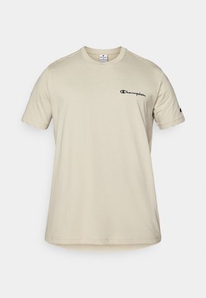 Beige Kurzarm-T-Shirt aus Baumwolle mit schwarzem "Champion"-Logo auf der linken Brust und einem kleinen Logo auf dem rechten Ärmel.