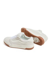 Baskets en suede blanc à profil bas, avec des perforations, des lacets blancs et une semelle en caoutchouc gomme avec un motif de traction.
