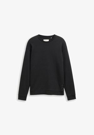 Mustra mustusega dressipluus, ümmarguse kaelusega, pikkade varrukatega ja ribakujundusega. Alumises vasakus nurgas on väike brändi silt.