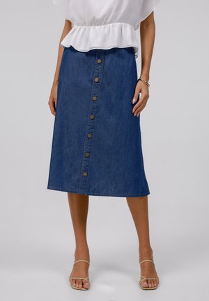Jeans midi skjørt med rett snitt, lys blå farge, frontlukking med knapper og sydd kant. Kombinert med en hvit peplum topp.