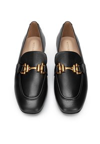 Černé kožené mokasíny s plochou podrážkou, zdobené zlatým dekoračním sponou a hladkým povrchem. Jednoduchý, elegantní design s kulatou špičkou.