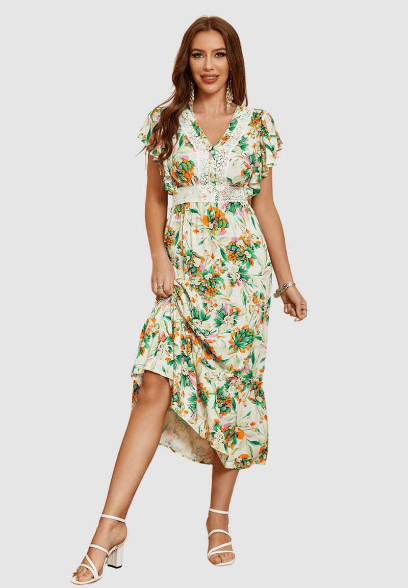 Vestido maxi floral con mangas cortas acampanadas, una cintura de encaje ajustada y un dobladillo asimétrico. La tela presenta patrones vibrantes en verde y naranja.