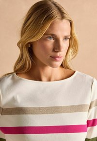 Adīts tops ar plašu kakla izgriezumu; satur horizontālas svītras baltā, bēšā, zaļā un spilgti rozā krāsā. Mīksta tekstūra ar pieguļošu siluetu.