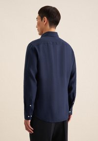 Marineblauw overhemd met knopen, gemaakt van een gestructureerde stof, met een kraag, lange mouwen met knopen bij de manchetten en een afgeronde zoom.