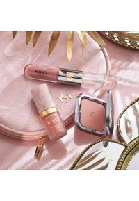 Blush liquide KIKO Milano, couleur à lèvres double embout et blush compact sur une pochette rose avec fermeture éclair dorée et bords de miroir décoratifs.