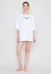 Weißes, übergroßes T-Shirt aus Baumwolle mit kurzen Ärmeln und einem Logo "JOOP! JEANS" mit einem Herz, weicher Textur und entspannter Passform.