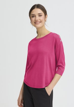 Leuchtend pinker Pullover mit dreiviertel Ärmeln, rundem Ausschnitt und dekorativen Knopfdetails an der Schulter. Hergestellt aus weichem Strickmaterial.