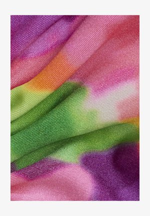 Gros plan sur un tissu brillant avec des motifs abstraits de teinture à la noue en nuances de rose, violet, vert et orange.