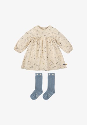 Robe en coton beige avec imprimé d'étoiles et de fusées, associée à des chaussettes bleu roi montantes avec des accents d'étoiles blanches.