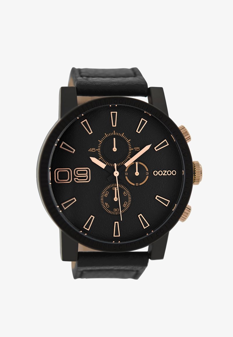 Montre noire avec un cadran noir texturé, indices et accents en or rose, trois sous-cadrans, et un bracelet noir mat. Marque : OOZOO.