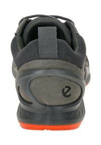 Zwart sportief schoen met een gestructureerde stoffen bovenkant, een stevige hielcounter en een oranje accent op de zool. Van rubber gemaakte loopzool zorgt voor grip.