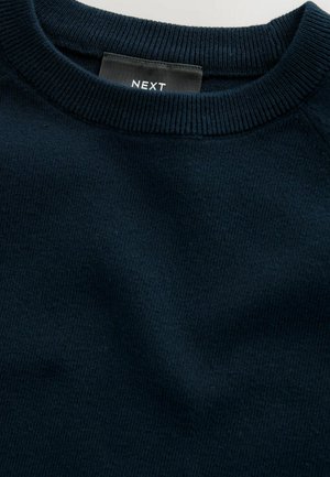 Granatowy sweter z prążkowanym okrągłym dekoltem. Wykonany z miękkiego, teksturowanego materiału. Widoczna metka z logo "NEXT".
