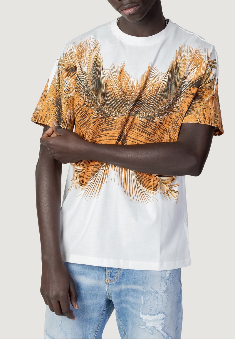 White cotton t-shirt featuring a large orange and black palm leaf print across the front. Short sleeves and relaxed fit design.
