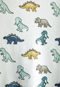 Wzór kolorowych kreskówkowych dinozaurów, w tym żółtego stegozaura, niebieskiego stegozaura, triceratopsa i zielonkawo-niebieskiego T-Rexa na białym tle tkaniny.