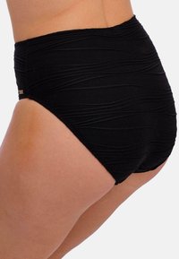 Vysoké černé bikiny s texturovanou, vlnkovou tkaninou. Mají zvýrazněné švy a jemný siluetu, navržené pro pohodlí a dokonalé padnutí.