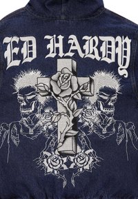 Jeansjacke mit weißem besticktem Text "ED HARDY", der ein zentrales Kreuz, Rosen und Schädel-Designs in Grau und Weiß zeigt.