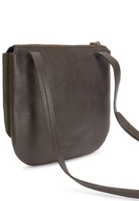 Tamnosmeđi kožni crossbody ranac s dugim remenom i gornjim zatvaračem, prikazuje teksturiranu površinu i suptilno ugravirani logo brenda.