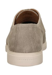 Beige suède schoen met een afgeronde hak, voorzien van een gladde textuur en een crème-kleurige rubberen zool. Minimalistisch ontwerp, geen extra hardware.