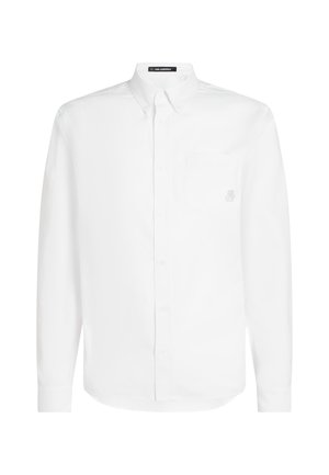 Camisa blanca de manga larga hecha de algodón, con cuello abotonado, bolsillo en el pecho y un sutil bordado del logo en el bolsillo.
