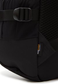 Svart ryggsäck med texturerad tyg, släta nylon accenter, justerbar rem och en Cordura®-etikett. Triangulär sömm detaljer synliga.