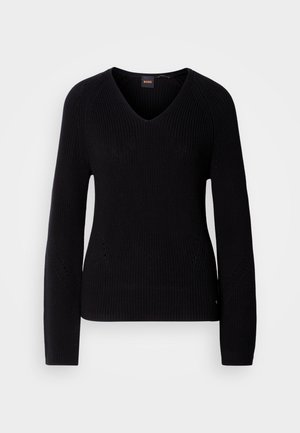 Μαύρο πουλόβερ με λαιμόκοψη σε σχήμα V, με υφή ριμπ πλεκτού, μακριά μανίκια και διακριτικές περφορέ λεπτομέρειες στα πλάγια. Η ετικέτα του brand είναι ορατή στο λαιμό.