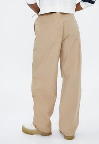 Beige, lette cargo-bukser med afslappet pasform, der har to baglommer og justerbar snøre i taljen.