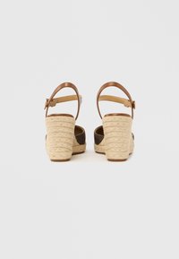 Καφέ δερμάτινα σανδάλια με τακούνι, υφασμένο πλατφόρμα από τζούτ, ρυθμιζόμενο λουράκι στον αστράγαλο και ανοιχτή σχεδίαση πίσω. Διαθέτουν υφή από φυσικές ίνες.