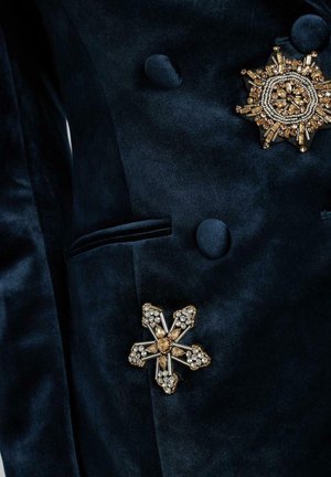 Marineblauer Samtblazer mit goldenen und kristallinen Blumenbroschen. Verfügt über ein doppelreihiges Design und eine elegante, glatte Textur.