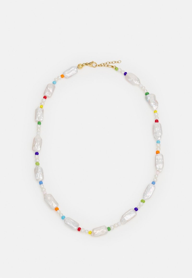 Collier avec des perles blanches irrégulières alternant avec de petites perles rondes multicolores et un fermoir chaîne doré sur fond blanc.