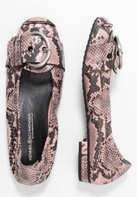 Zapatos planos de estampado de serpiente en rosa y negro con punta redonda, acento de hebilla plateada, suela de goma y acabado de cuero texturizado.