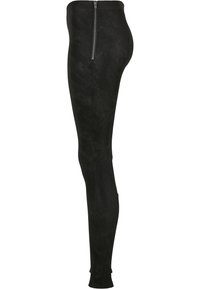 Pantalon skinny noir taille haute avec tissu texturé et une fermeture éclair latérale argentée allant de la taille à la hanche.