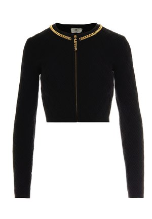 Veste noire cropped avec manches longues, en tissu texturé présentant un motif géométrique, et accent en chaîne dorée le long du col.