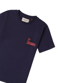 Camiseta de algodón azul marino con cuello redondo. Presenta un logotipo gráfico en rojo y negro en la zona del bolsillo del pecho izquierdo. Manga corta.