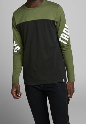 Long-sleeve shirt featuring an olive green upper section and black lower section. White text on the sleeves, cotton material, casual fit.