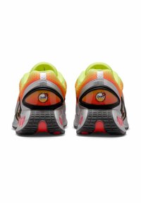 La chaussure présente un design principalement gris avec des accents vifs jaunes et oranges. Marquage Air Max au niveau du talon, supérieure en mesh texturé et semelle en caoutchouc.