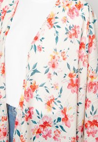 Kimono floral en tissu léger avec un fond blanc orné de fleurs roses et orangées, de feuilles vertes et d'une texture rayée subtile.