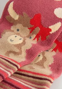 Gestrickte Socken in Pink mit braunen Tiermotiven und roten Akzenten. Merkmale sind gestreifte Bündchen mit weicher Textur und verspielten Designelementen.