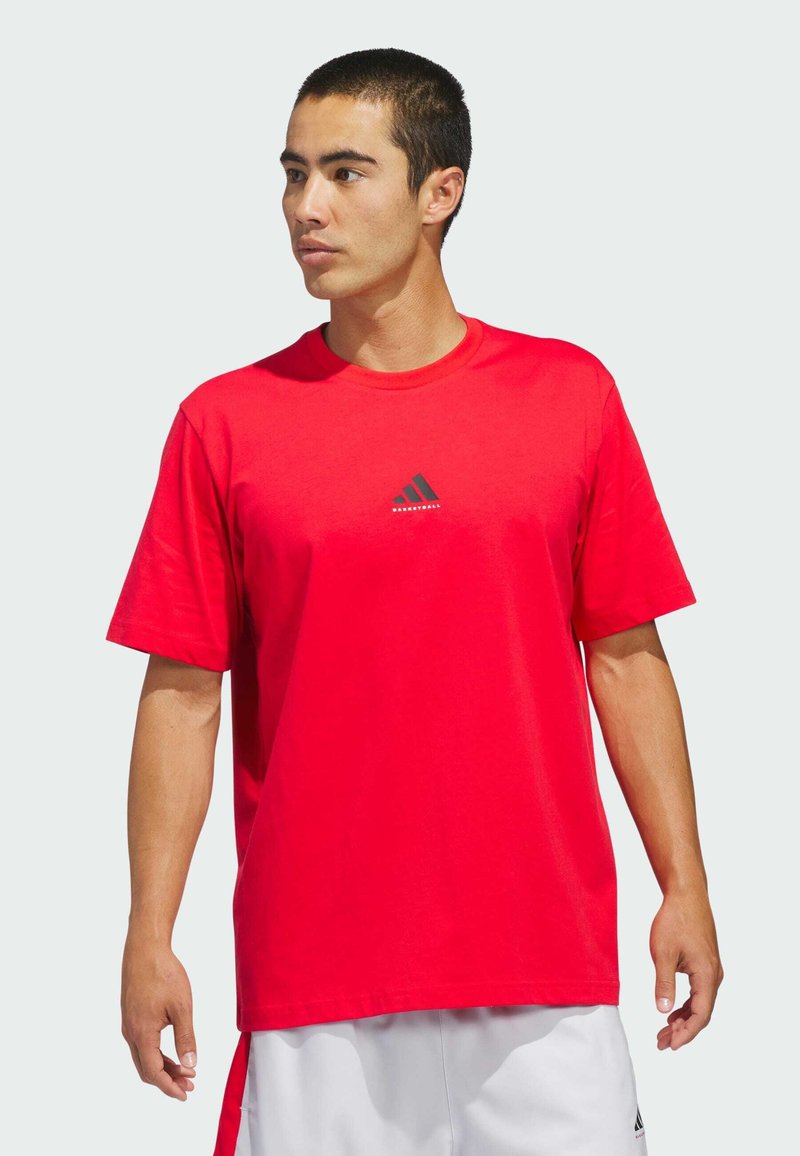 Rød bomulds T-shirt med korte ærmer, rund hals, med et lille sort Adidas-logo på brystet. Glat tekstur, casual pasform.