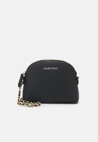 Černá kožená crossbody taška s kulatým tvarem, zlatou kováním, zipovým uzávěrem a dekorativním zlatým řetízkem. Uvedeno logo "VALENTINO".