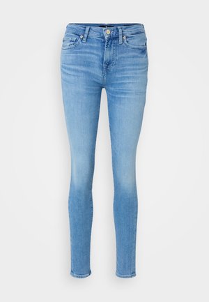 Jeanși skinny de culoare albastră deschisă din denim. Au cinci buzunare, închidere cu nasture și un ușor efect de decolorare pe material.