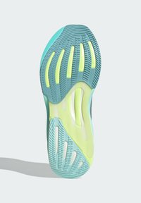Suola della scarpa con un design testurizzato in acqua e giallo neon, dotata di scanalature per la trazione e aperture per la ventilazione a supporto del comfort.