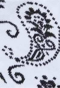 Schwarz-weißes Textil mit einem Paisleymuster, das komplizierte Wirbel und florale Designs auf einem strukturierten Stoffhintergrund zeigt.