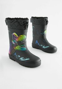 Gli stivali in gomma neri presentano una grafica colorata di un dinosauro con cuffie, un collare con trapuntatura testurizzata e un design maculato in blu e verde.