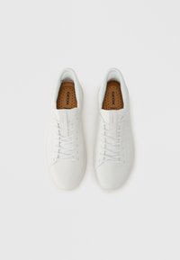 Baskets en cuir blanc avec une texture lisse, design à lacets, col rembourré et semelles intérieures perforées. Comprend un logo Geox marron sur les semelles intérieures.