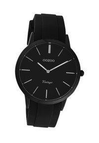 Montre noire avec un bracelet en silicone à finition mate, cadran rond simple, marqueurs d'heure et aiguilles argentés, avec la marque "OOZOO Vintage" sur le cadran.