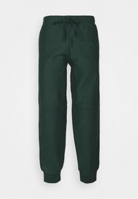 Mörkgröna sweatpants med elastisk midja, snörningsdetalj och avsmalnande ben. Mjukt tyg med förstärkta knäpaneler.