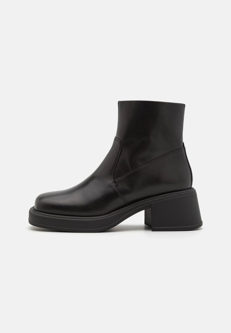 Bottine noire en cuir avec un talon bloc épais, un bout rond et une finition lisse, vue de côté extérieur sur fond blanc.