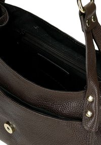 Brązowa torebka skórzana o teksturowanym wykończeniu, z pozłacaną magnetyczną klamrą, wewnętrzną kieszenią na zamek oraz regulowanym paskiem na ramię z nitami.