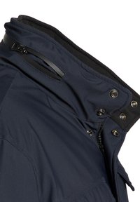 Chaquetón azul oscuro con alto collar, que cuenta con una cremallera y botones, confeccionado en tejido texturizado y que muestra un forro interior de felpa.