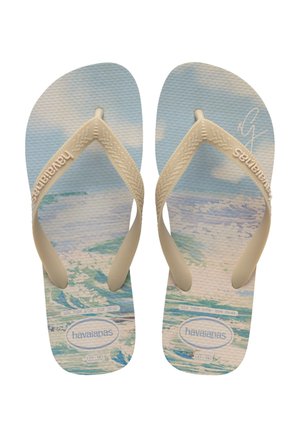 Chanclas Havaianas con tiras crema, que presentan un patrón oceánico azul y blanco en las suelas texturizadas. Tallas 37-38 y 39-40 indicadas.